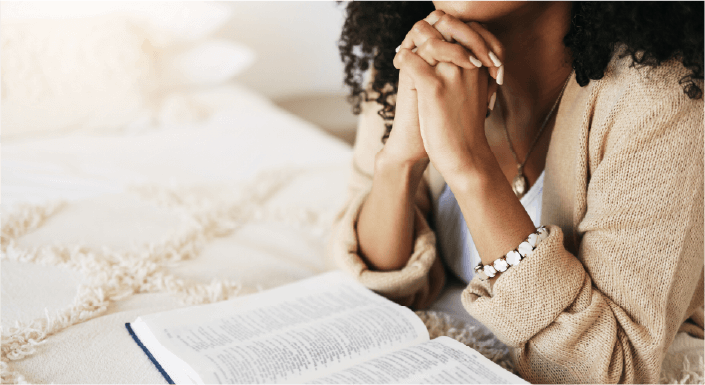 Female praying with open Bible - picture